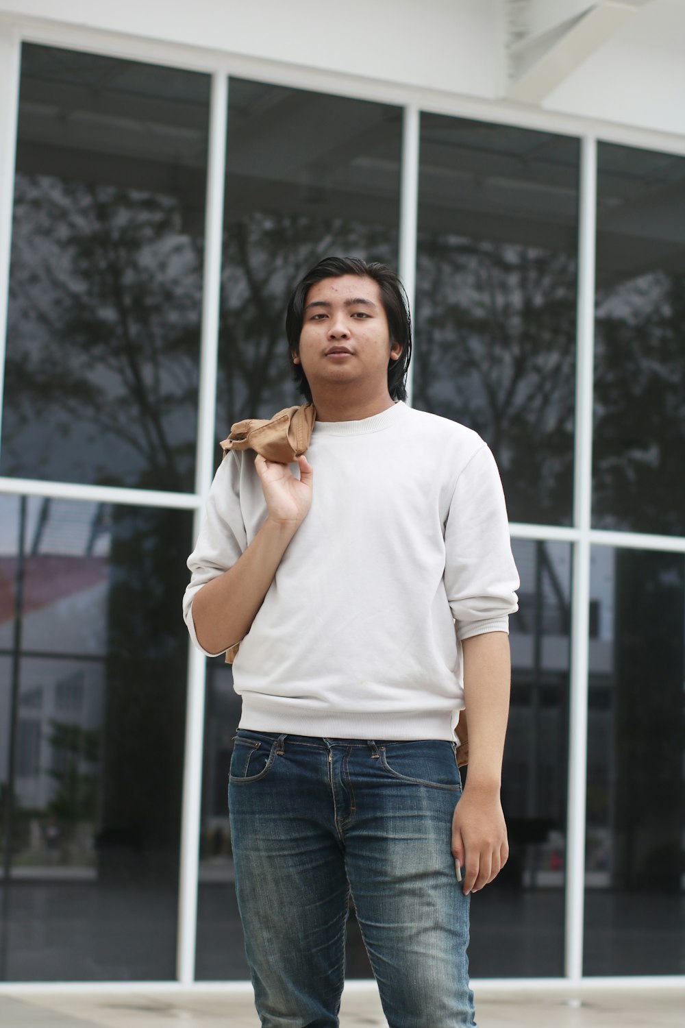 a man standing in front of a building holding a piece of food