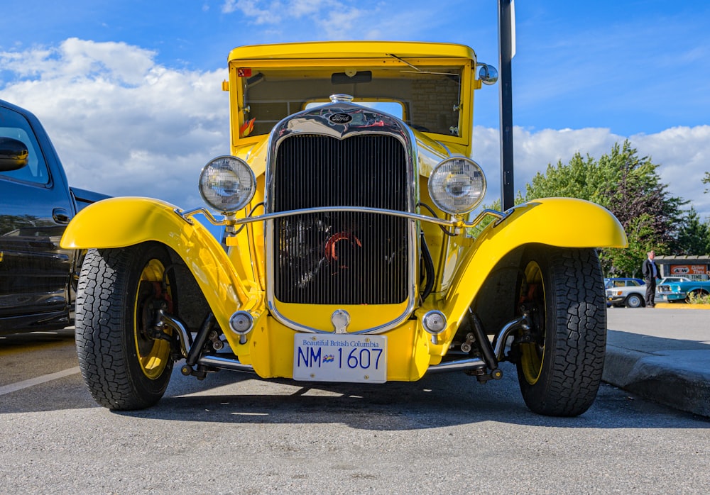 yellow vintage car on gray asphalt road during daytime