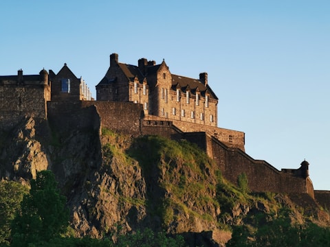 A historic stone castle illuminated by warm sunset light.