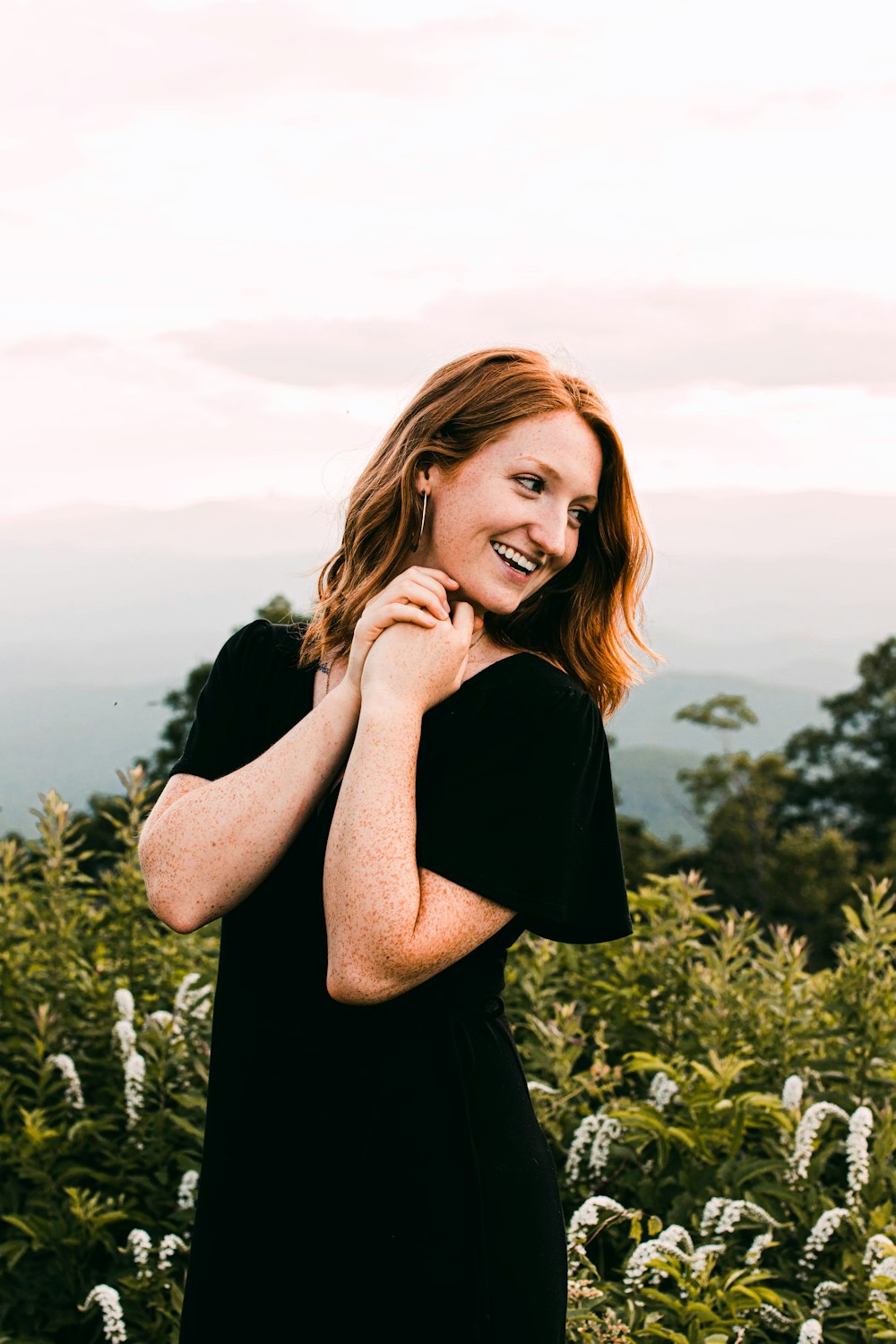 woman in black shirt standing on green grass field during daytime