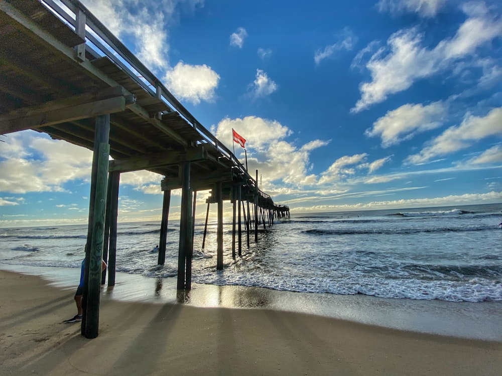 brown wooden dock on sea under blue sky during daytime