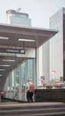 man in white dress shirt standing near glass window