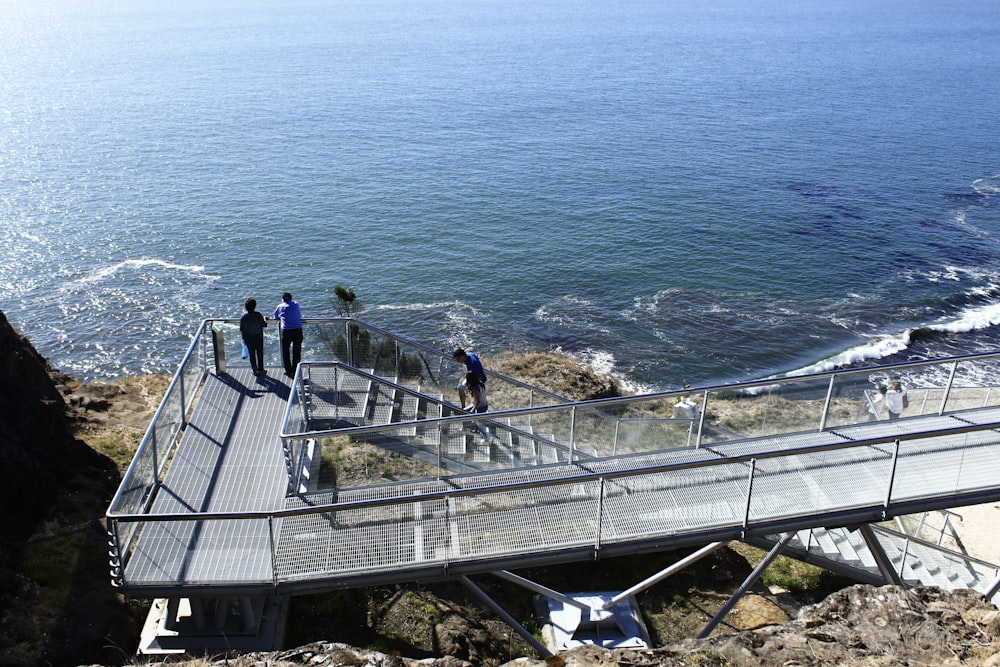 man and woman walking on wooden bridge