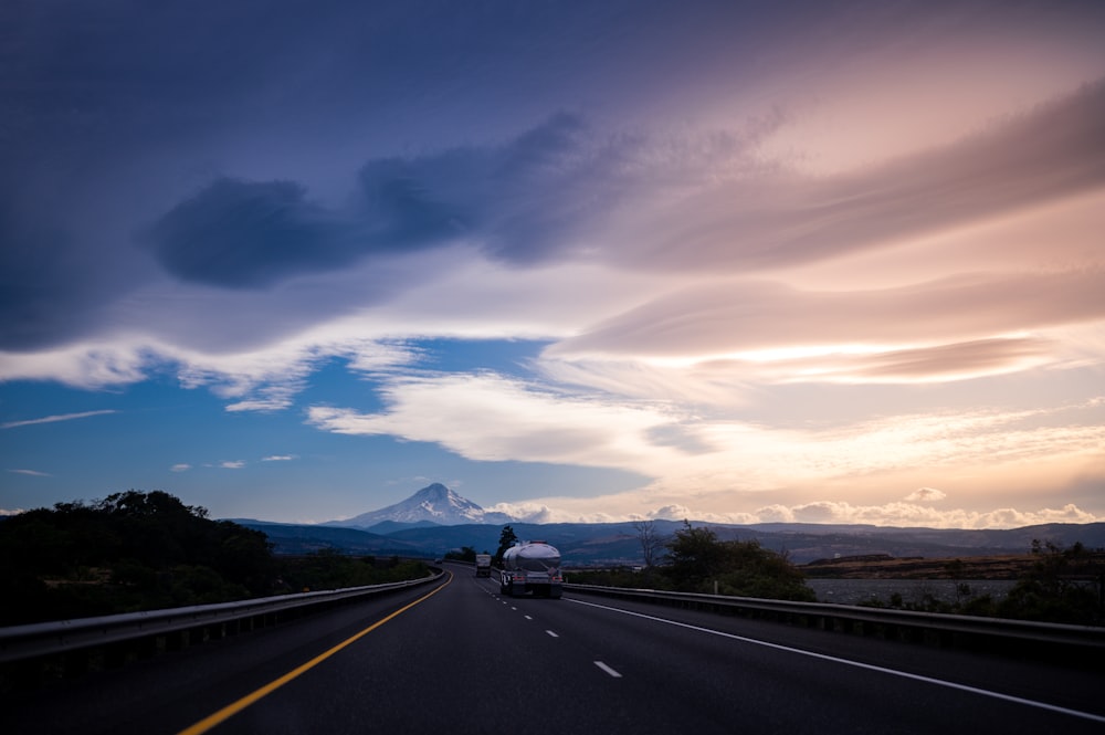 black car on road under cloudy sky during daytime