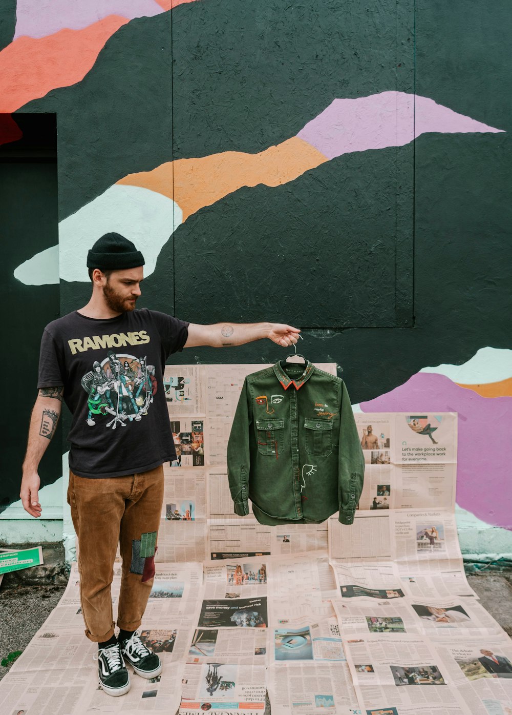 Man in black crew neck t-shirt and brown pants standing beside