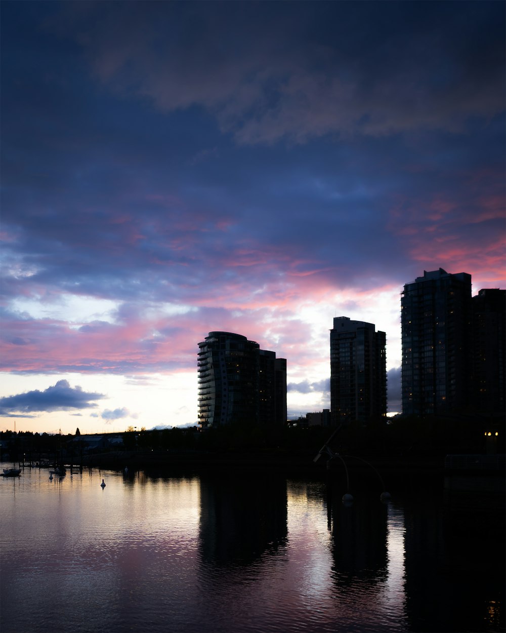 city skyline across body of water during sunset