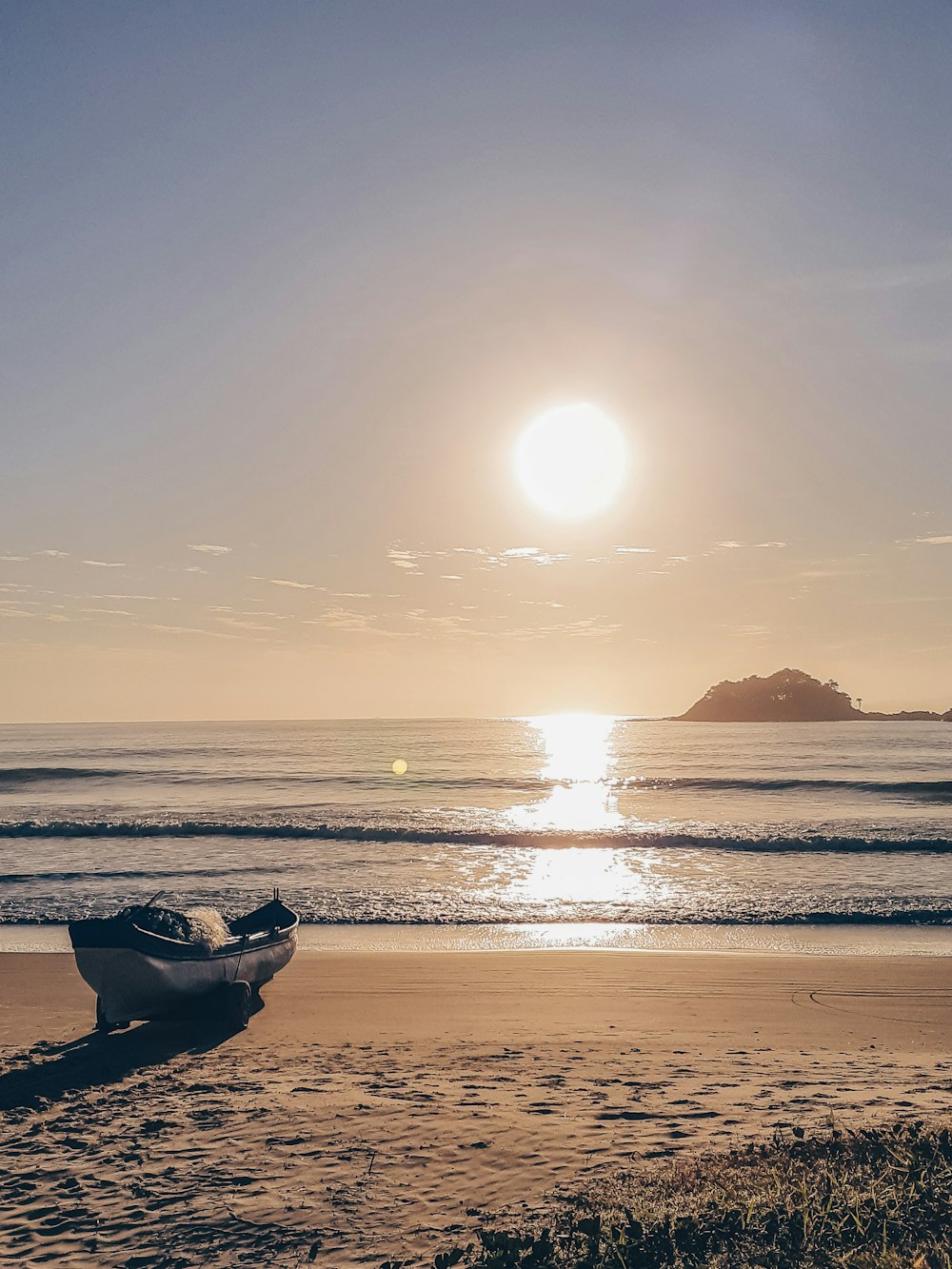 Silueta del barco en la playa durante la puesta del sol