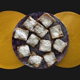 Elegant presentation of maamoul cookies dusted with powdered sugar on a traditional plate.