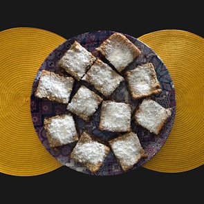 Elegant presentation of maamoul cookies dusted with powdered sugar on a traditional plate.
