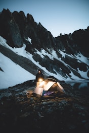 A compact ultralight tent pitched on rocky terrain at dawn.
