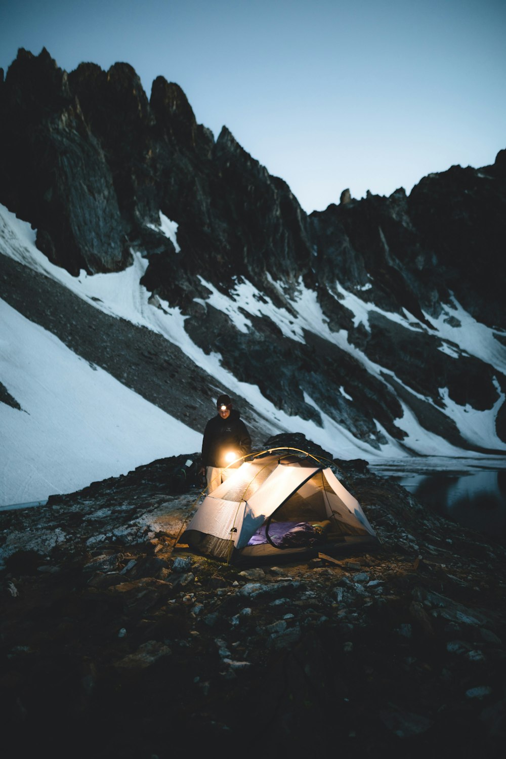 person in yellow dome tent in front of snow covered mountain during daytime