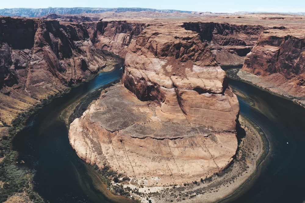 brown rock formation near blue water during daytime