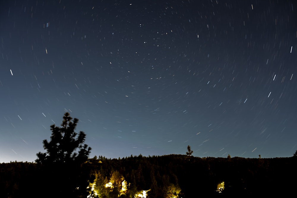 silhouette of person standing on hill during night time