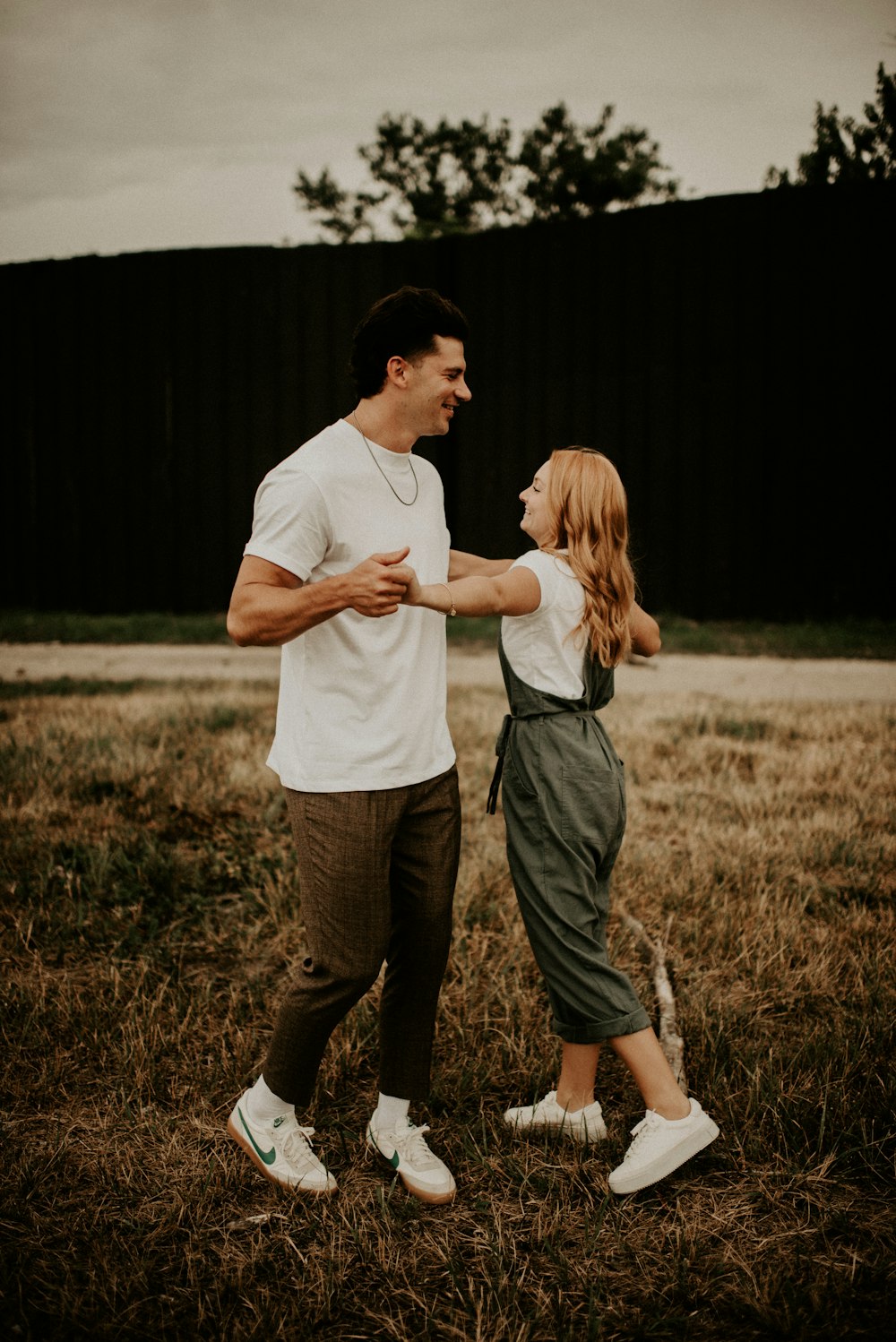 man in white t-shirt and green pants holding woman in white t-shirt