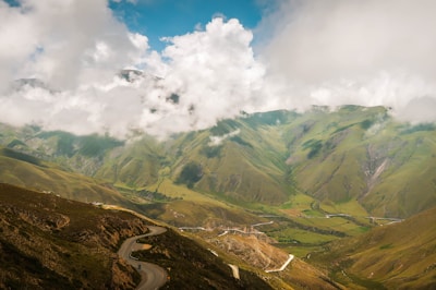 green and brown mountains under white clouds and blue sky during daytime