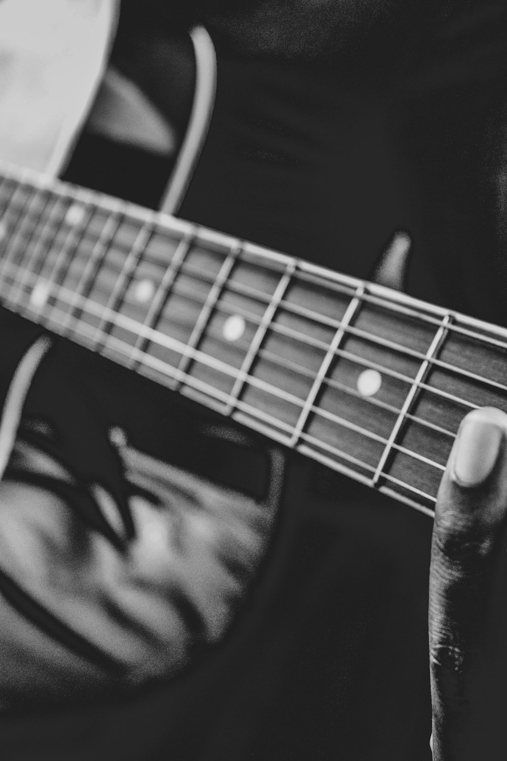 person playing guitar in grayscale photography