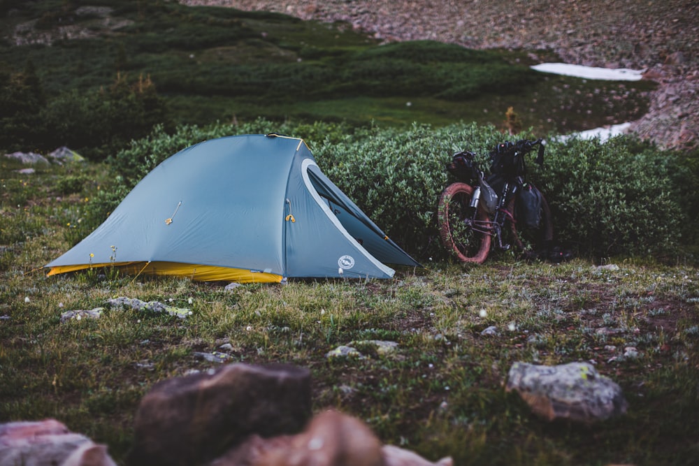 man in black jacket riding bicycle near yellow tent during daytime