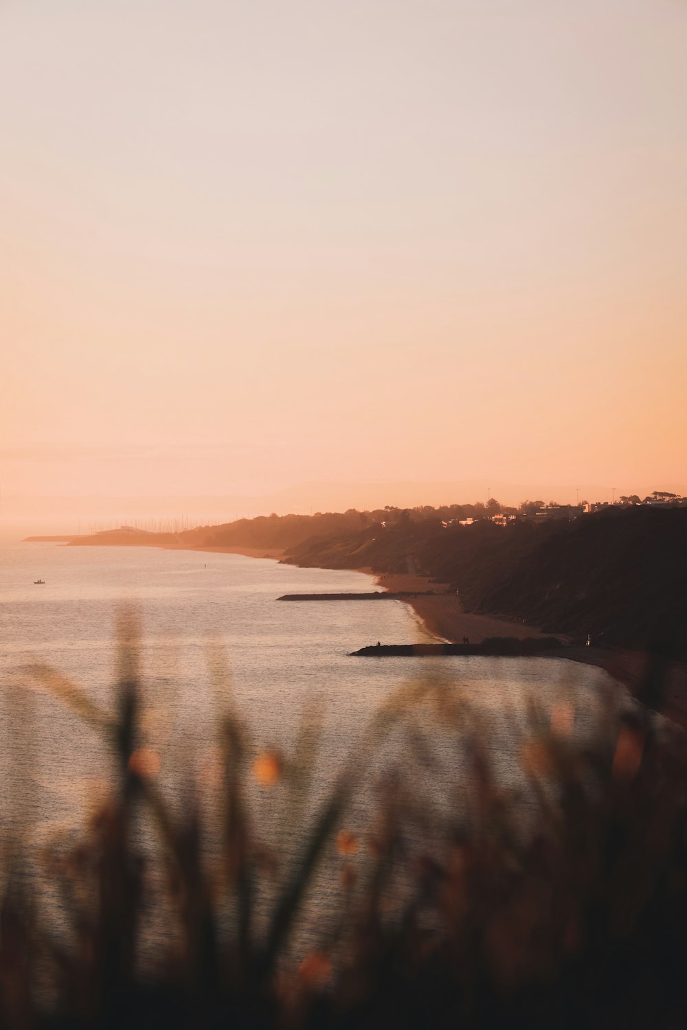 silhouette of mountain near body of water during sunset