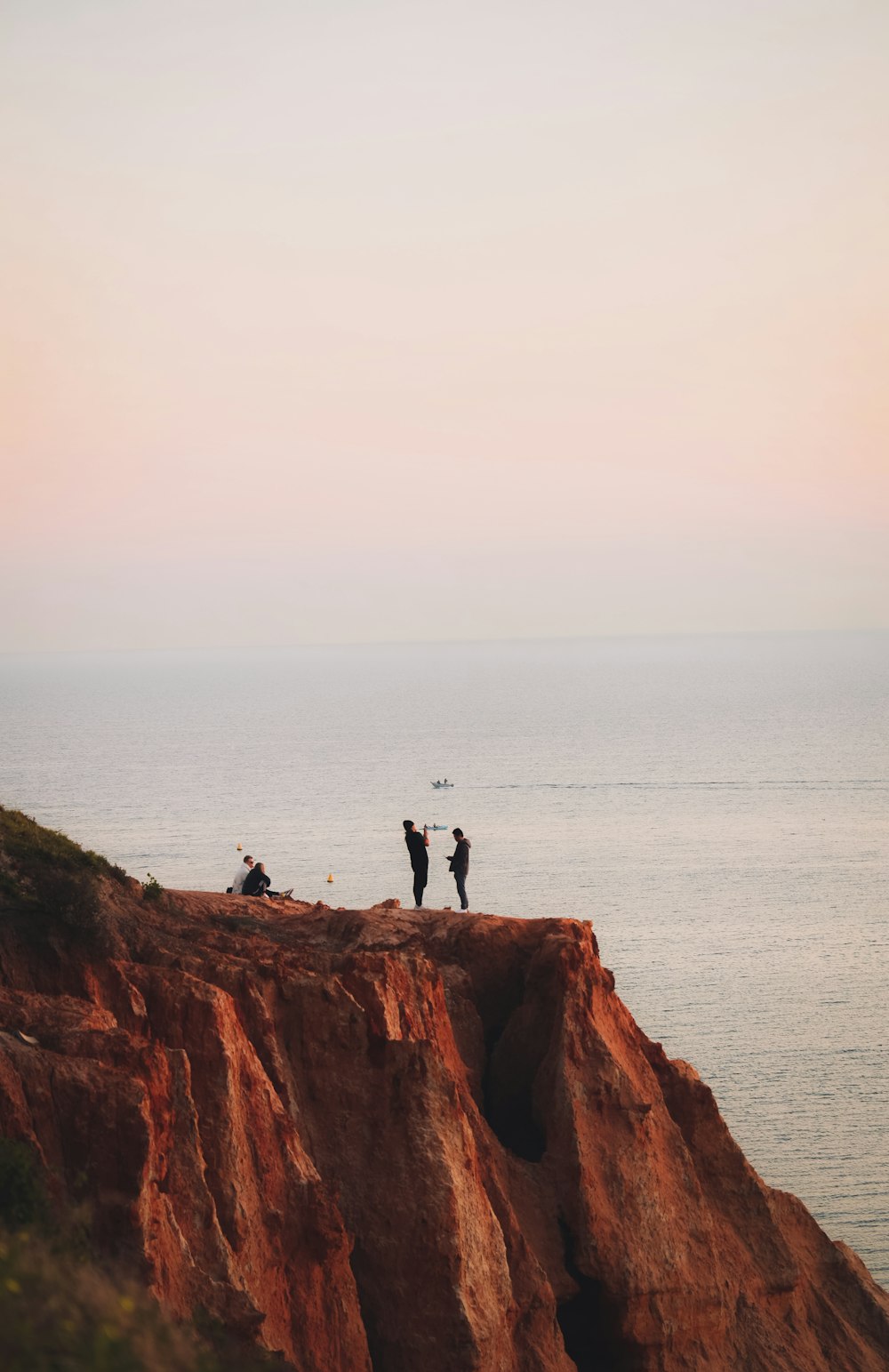 2 personnes debout sur une formation rocheuse brune pendant la journée