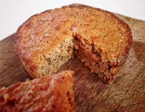 A close-up photo of a golden flour cake slice on a rustic wooden board.