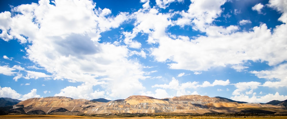 brown and white mountains under blue sky and white clouds during daytime