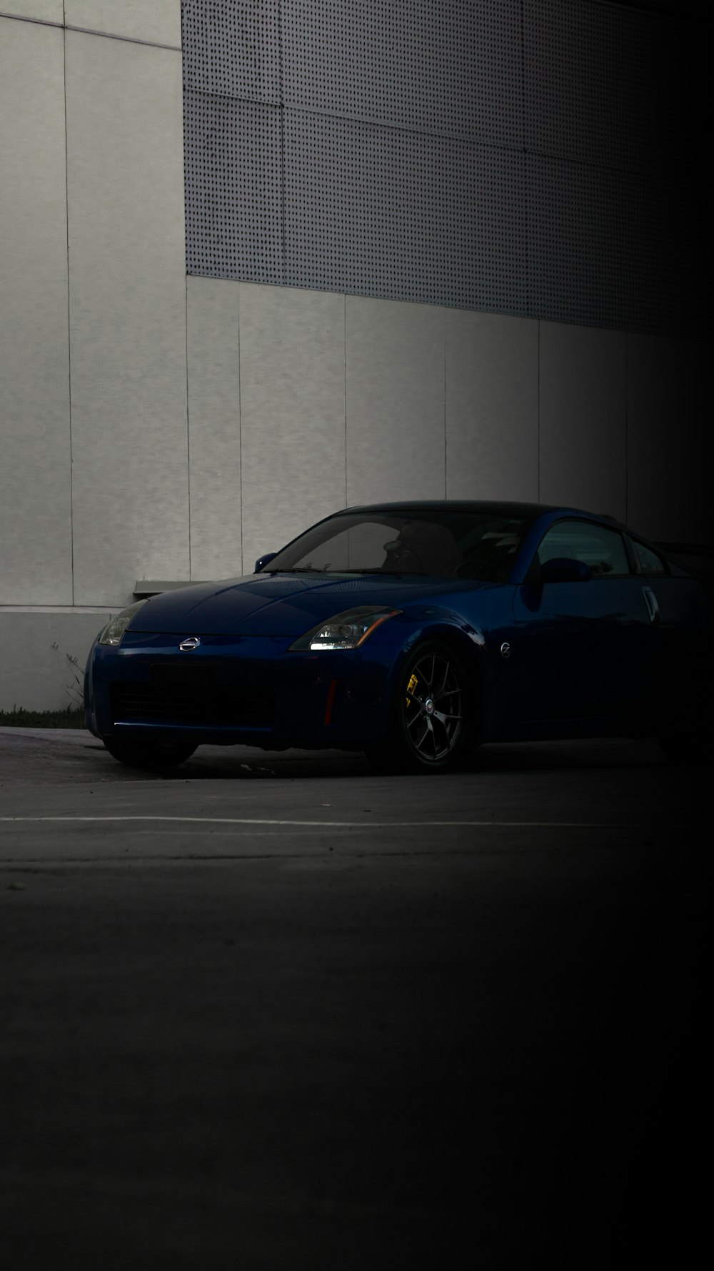 blue ferrari 458 italia parked near white wall