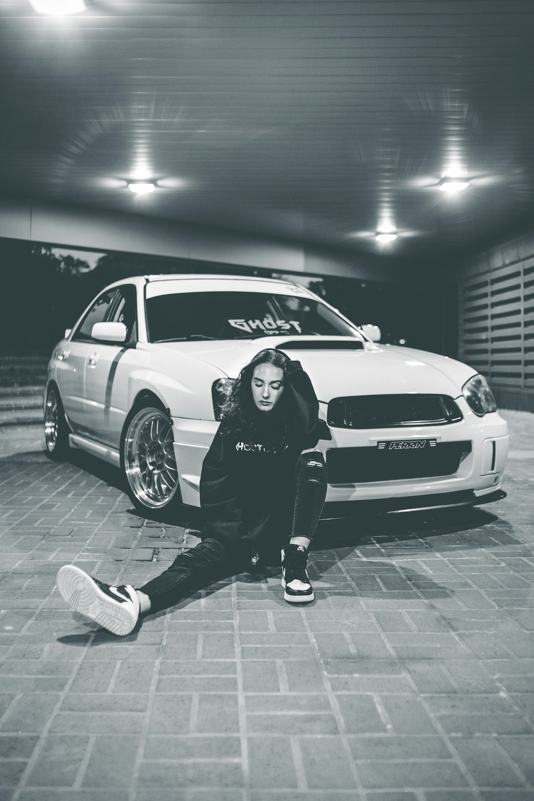 man in black jacket standing beside white bmw m 3