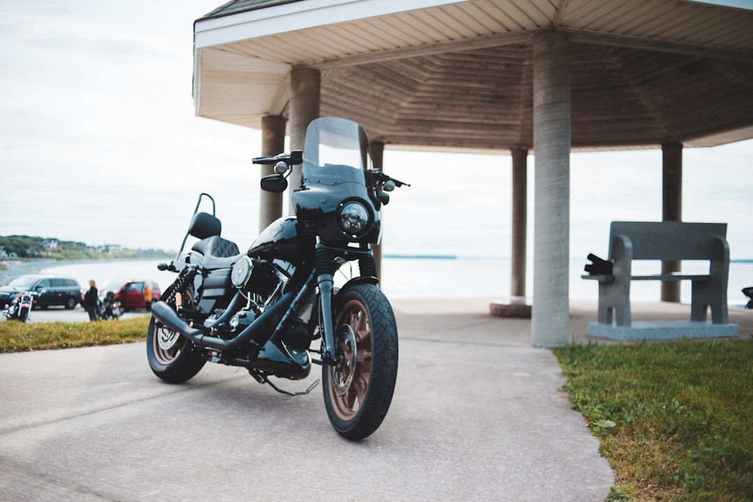 black and gray cruiser motorcycle parked on gray concrete pavement