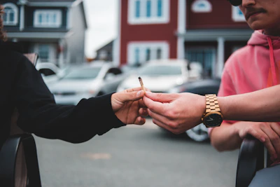 Urban streetwear-clad friends sharing homiez prerolls outdoors in golden light