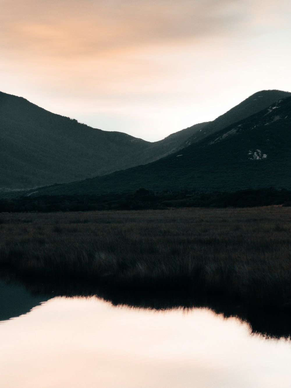 green mountains beside lake during daytime