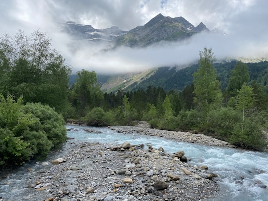 green trees near river under white clouds during daytime in Gavarnie France