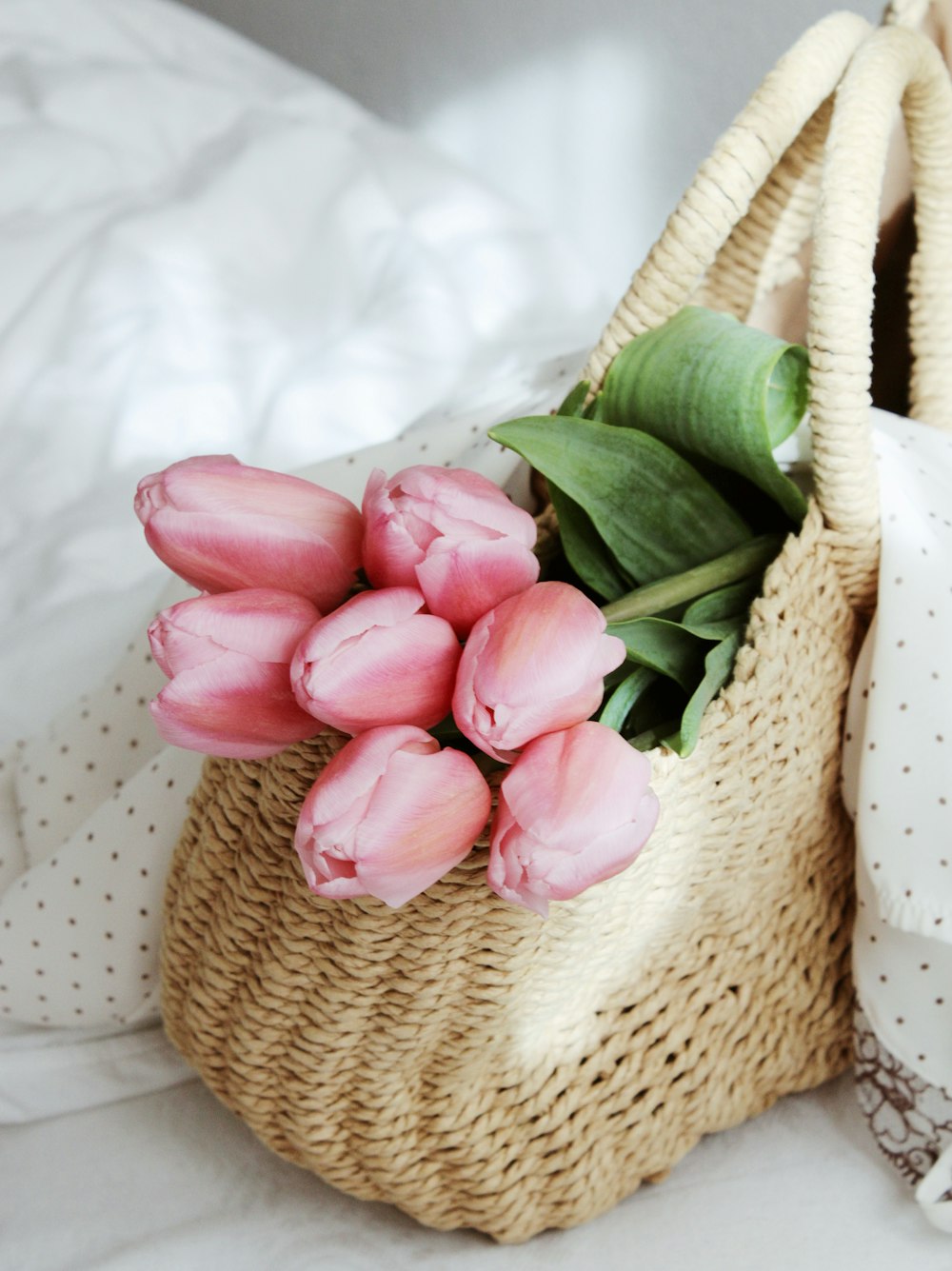 pink tulips on brown woven basket