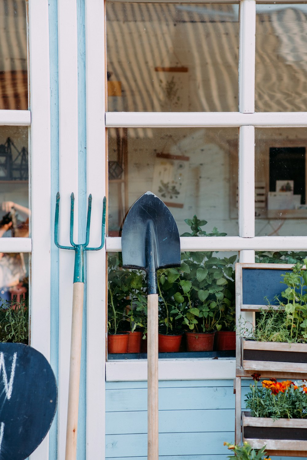 green and black shovel on white wooden framed glass window