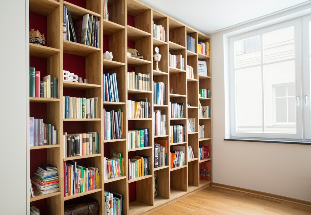 scaffali per libri in legno marrone vicino alla finestra