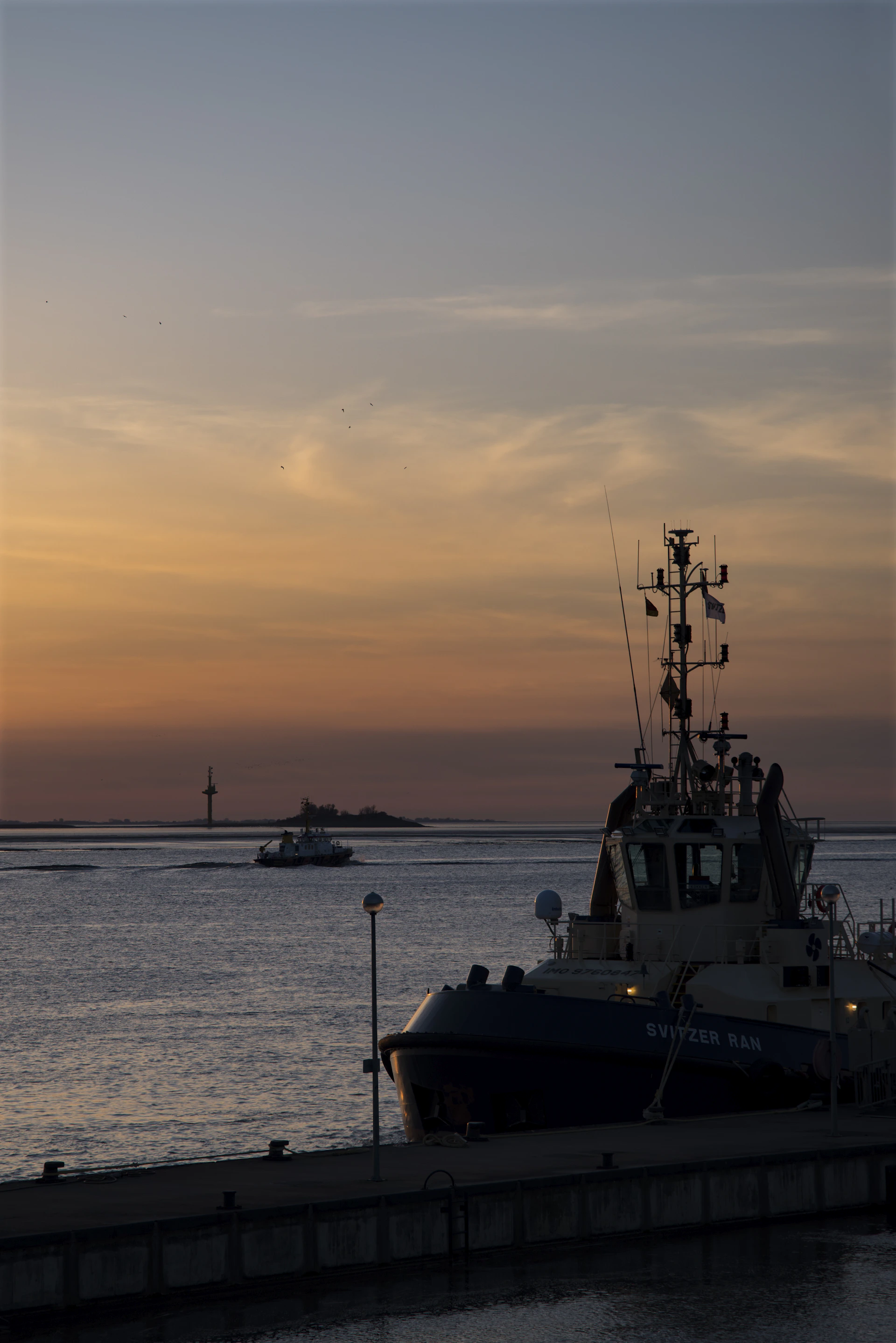 Vibrant scene of tŭg, the wise old tugboat, helping smaller boats in a bustling harbor under a warm golden light.