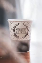 A premium paper cup with elegant gold foil accent, photographed with soft natural light.