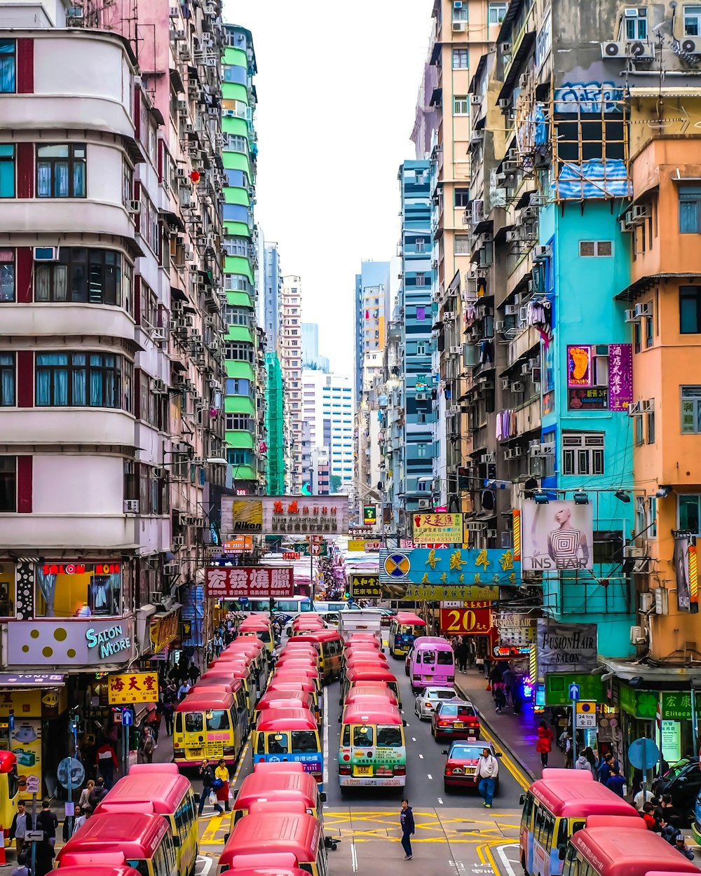 cars on road in between high rise buildings during daytime