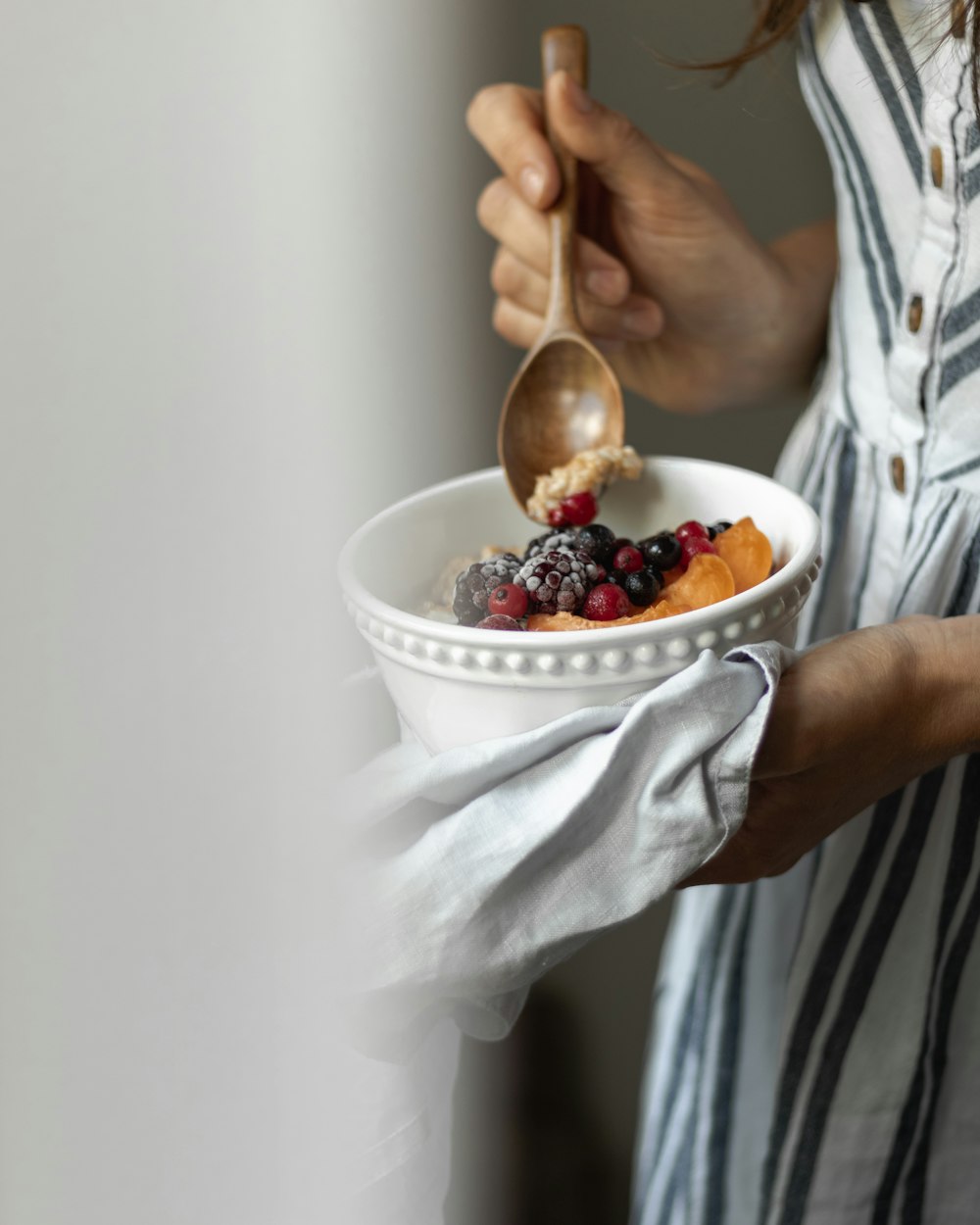 person holding white ceramic bowl with ice cream