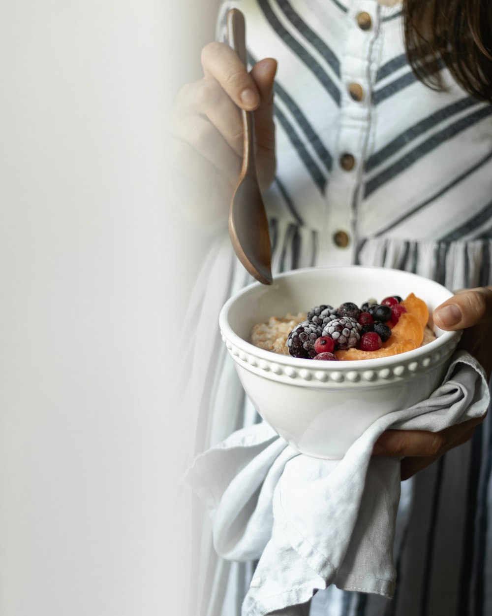 person holding white ceramic bowl with food