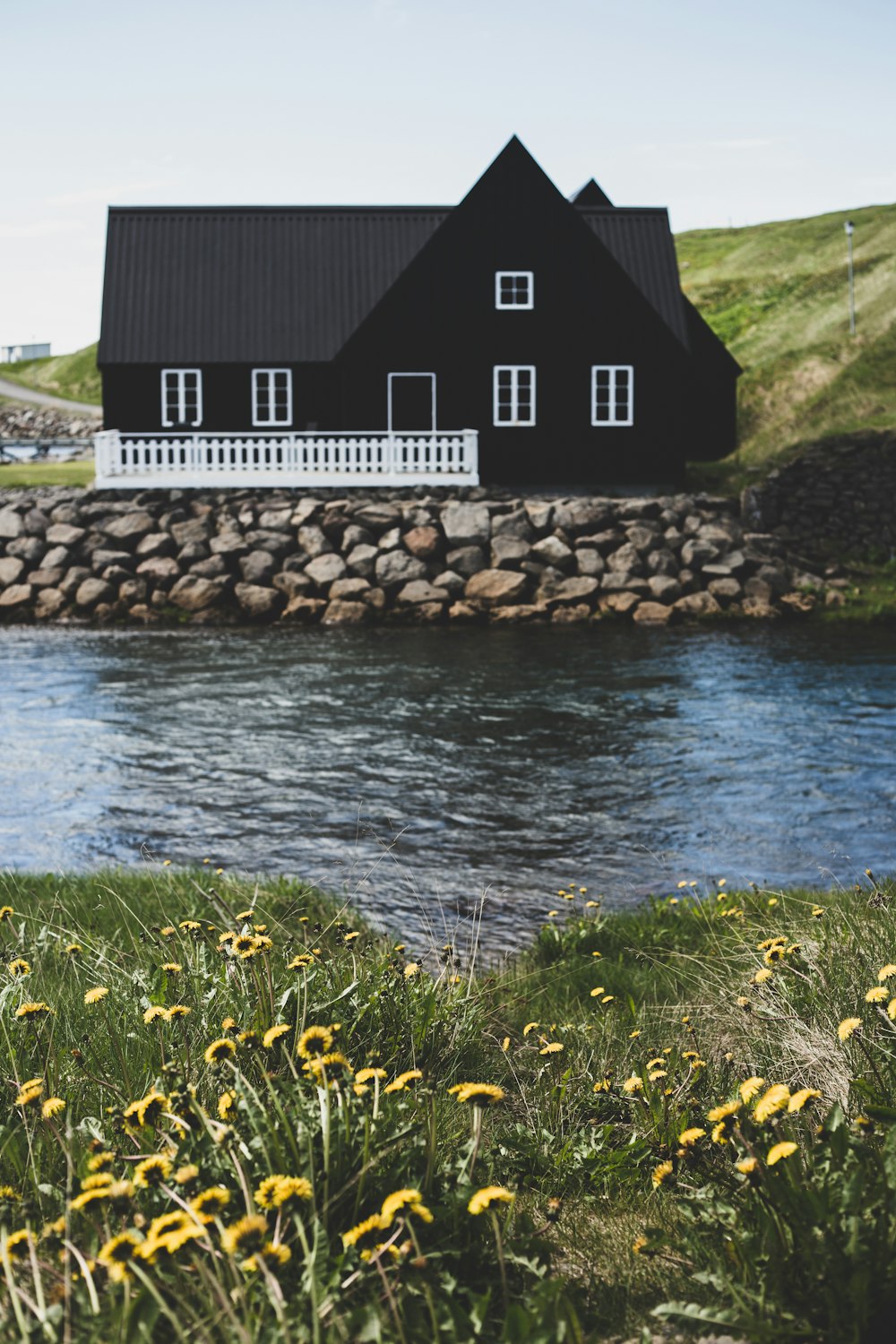 brown wooden house near body of water during daytime