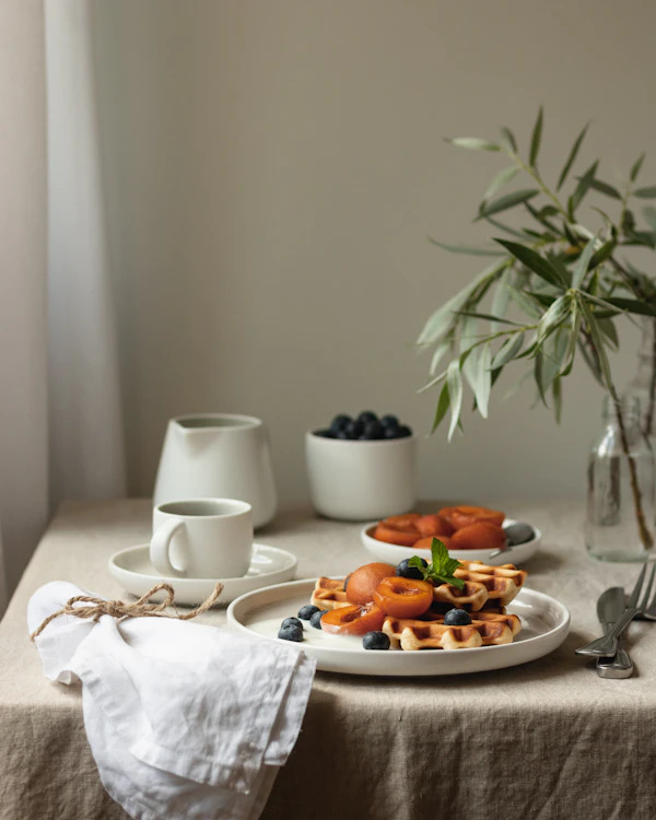 White ceramic mug on a white ceramic plate