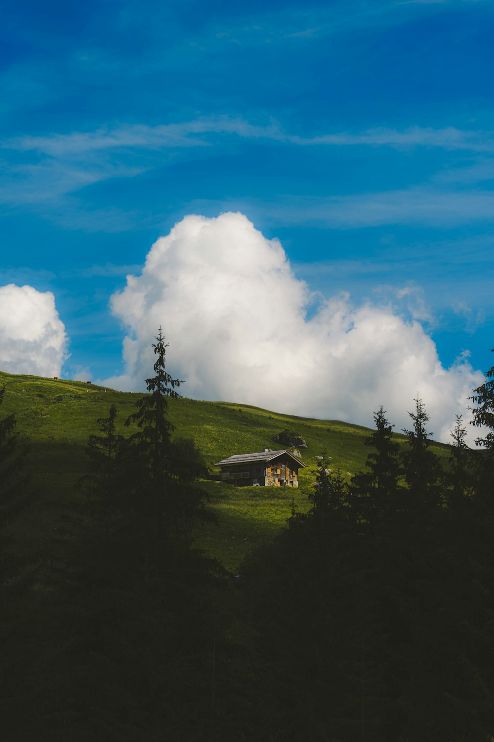 green mountain under blue sky and white clouds during daytime