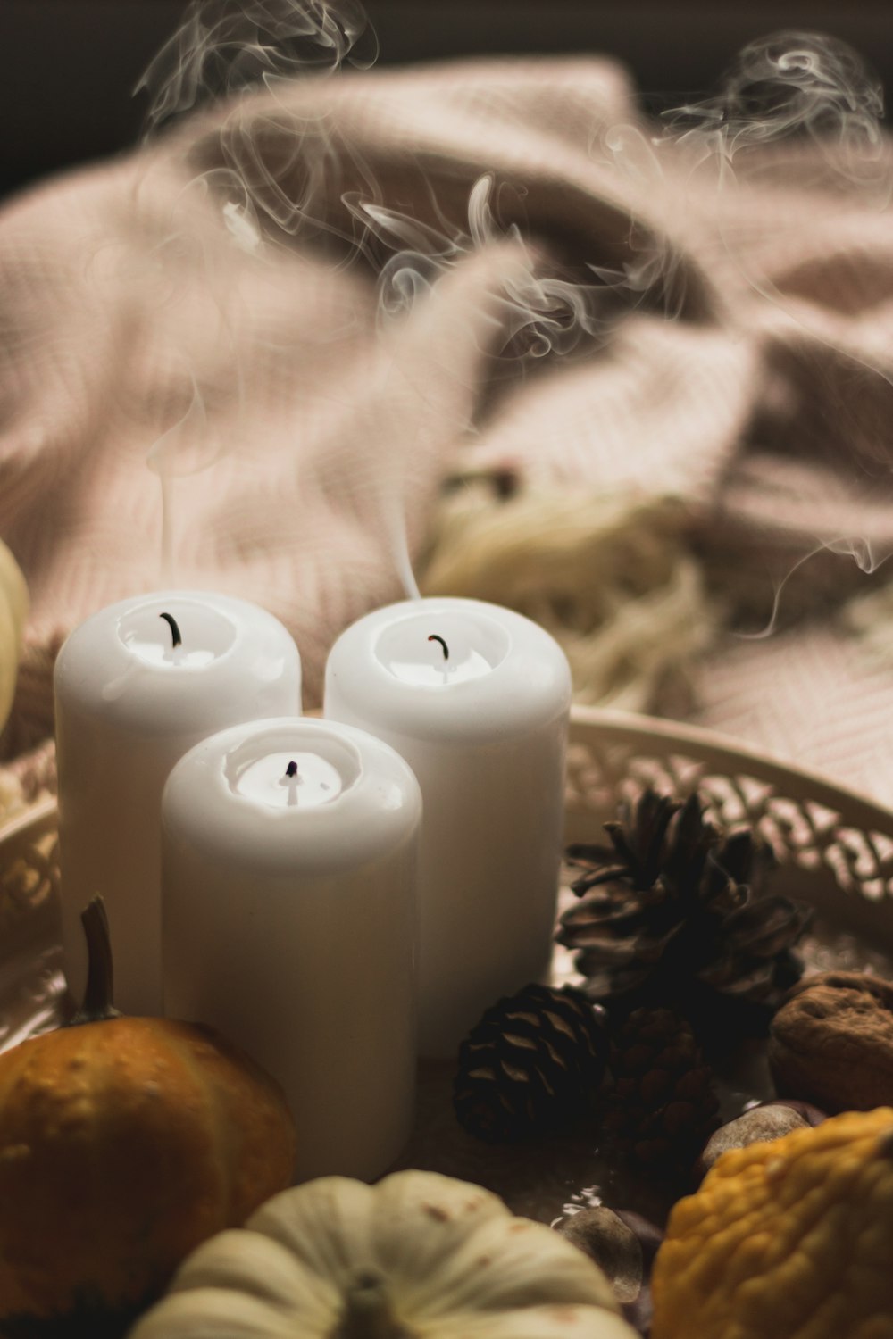 three white candles sitting on top of a plate