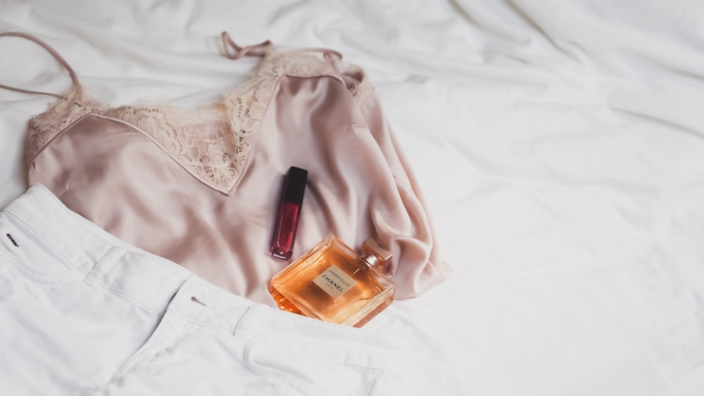 white leather jacket beside clear glass bottle