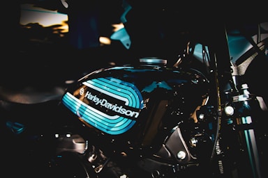 Close-up of a gleaming Harley Davidson motorcycle tank reflecting sunlight.