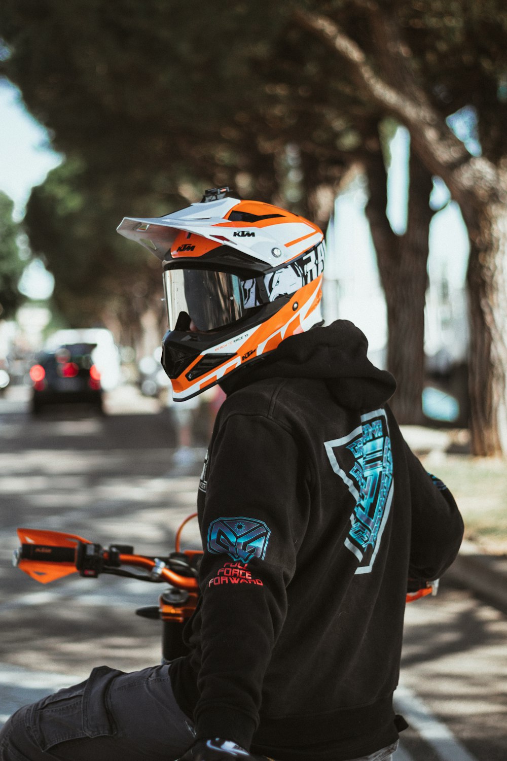 黒とオレンジのヘルメットと黒のパーカーを着て、オレンジと黒のナーフガンを持っている人の写真 – Unsplashの無料ペスキエーラ・デル・ガルダ写真