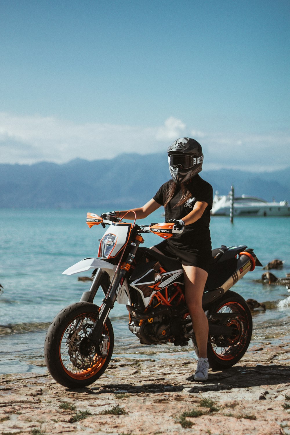 man in black helmet riding on red and white motorcycle during daytime