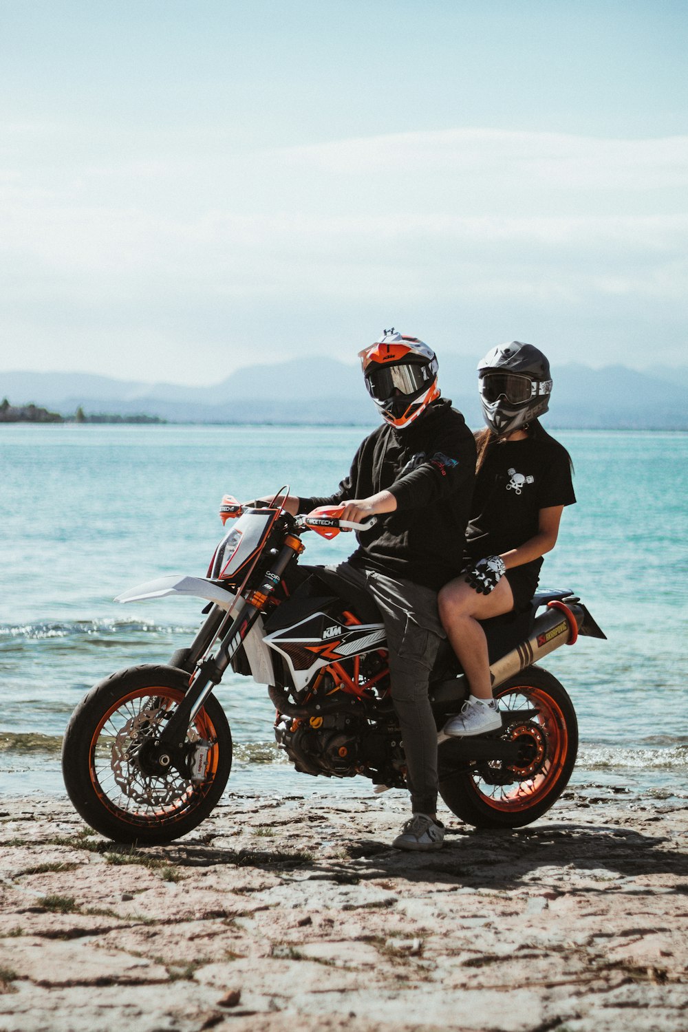 man in black shirt riding red and black motorcycle