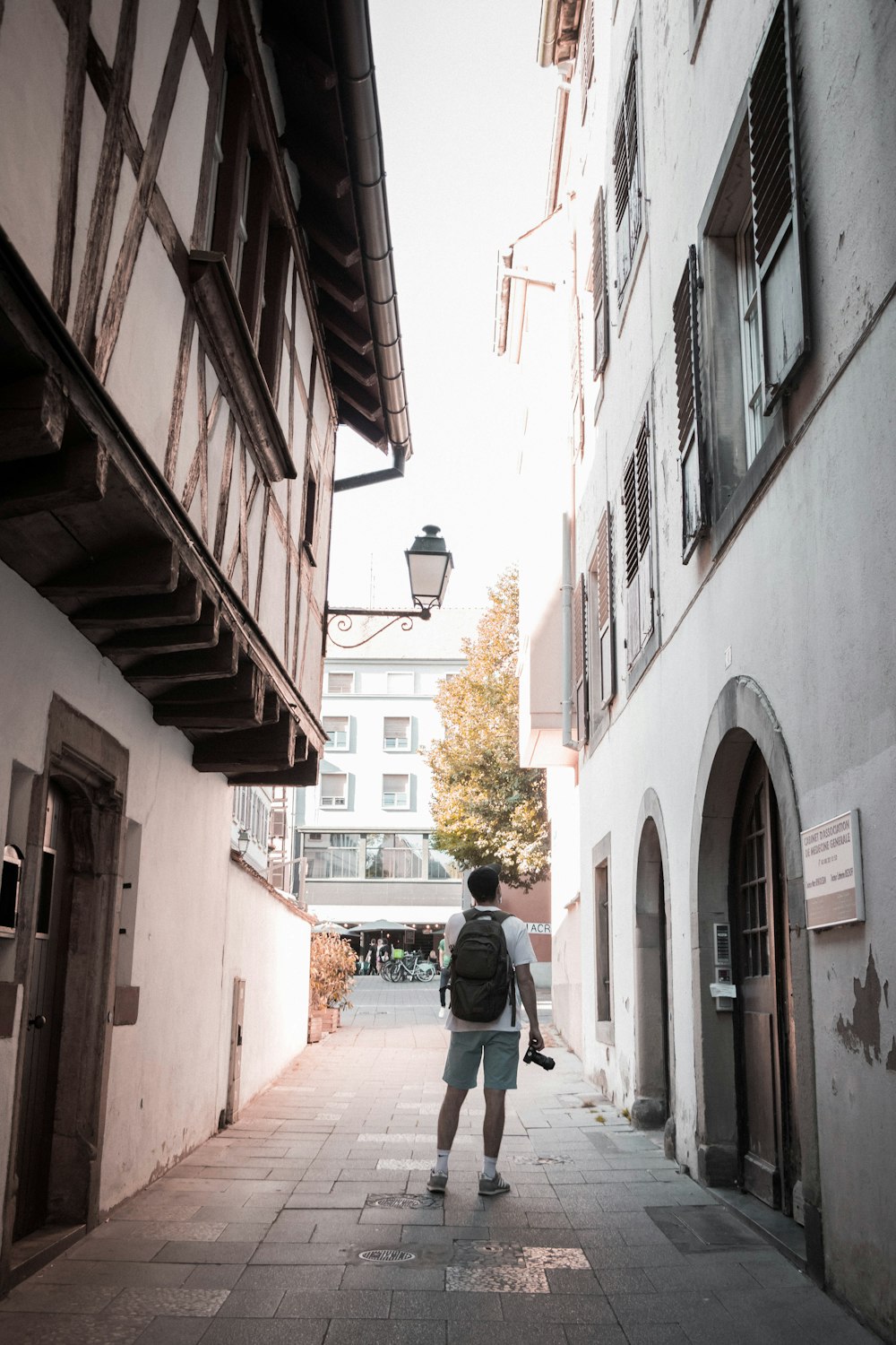 man in white long sleeve shirt walking on sidewalk during daytime