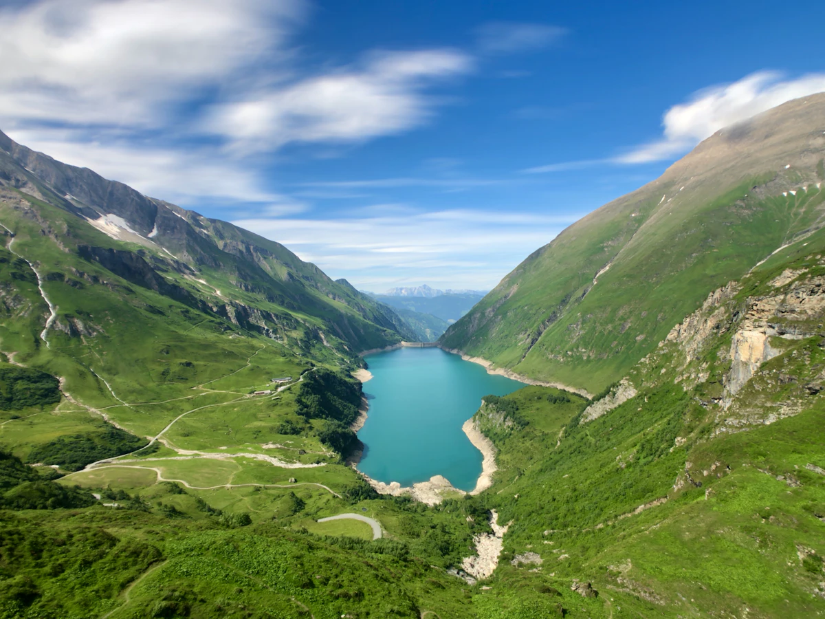 A turquoise reservoir in a steep green valley above Kaprun, seen from the Mooserboden road